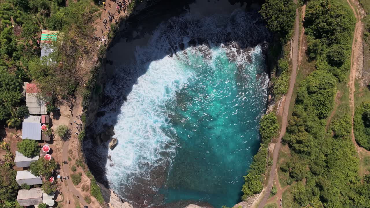 Flying over the spectacular natural rock arch and turquoise water of Broken Beach, Bali