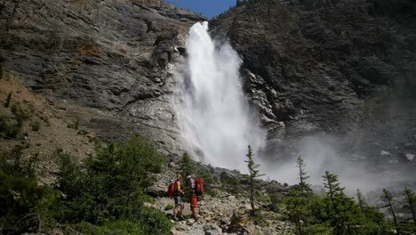 Side-view-of-young-caucasian-hiker-couple-with-backpack-standing-in-forest-on-a-sunny-day-4k