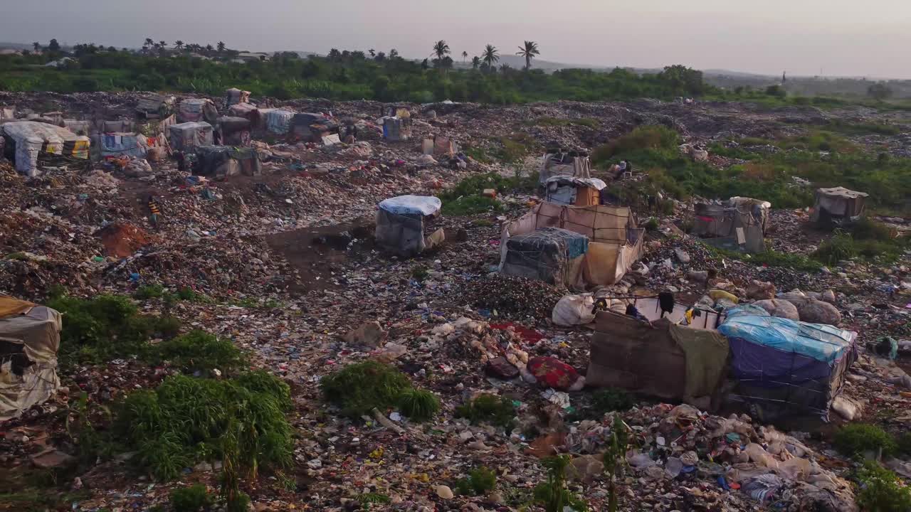 Stunning aerial orbit of a large landfill with a garbage picker walking in the background in Abuja, Nigeria