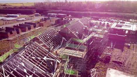 unfinished waterfront housing property development scaffolding framework on builders construction site aerial view