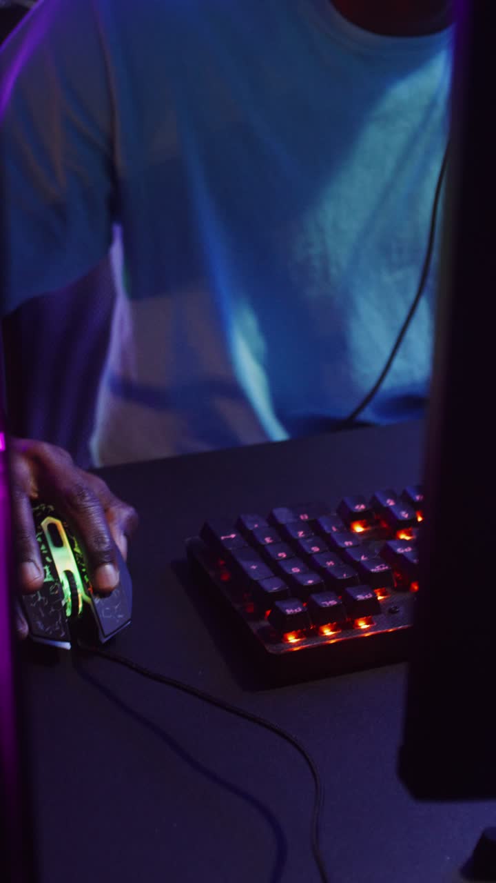 African American man playing video games with headset and keyboard