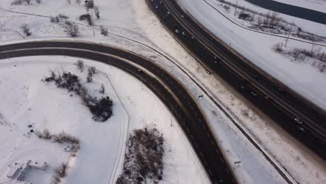 Luftaufnahme-Eines-Autos,-Das-Von-Einer-Stark-Befahrenen-Winterautobahn-Abfährt