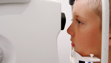 Optometrista-Femenina-Examinando-A-Un-Paciente-Joven-Con-Lámpara-De-Hendidura