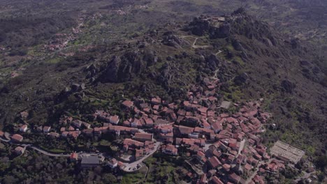 Toma-De-Arriba-Hacia-Abajo-Del-Pueblo-De-Monsanto-Portugal-Con-Castillo-En-La-Cima-De-La-Colina,-Antena