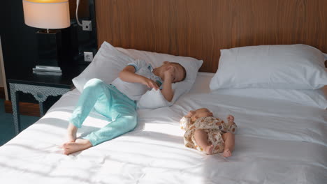 baby girl with elder brother on the bed at home