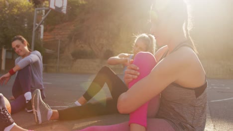 diverse female basketball team wearing sportswear, stretching