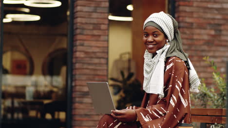 islamic woman posing with computer outdoors