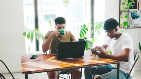 two young men working on a laptop