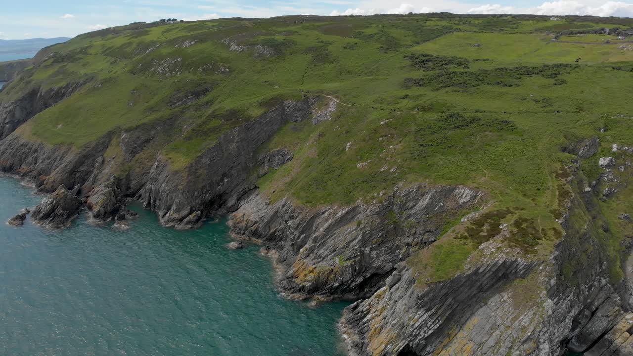 вид сверху вниз, панорамирование вверх, чтобы показать красивые зеленые ирландские горы на скале и голубое небо