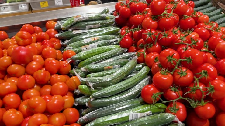 Camera pans across vibrant displays of fresh tomatoes and cucumbers in a Blue Mountains grocery.