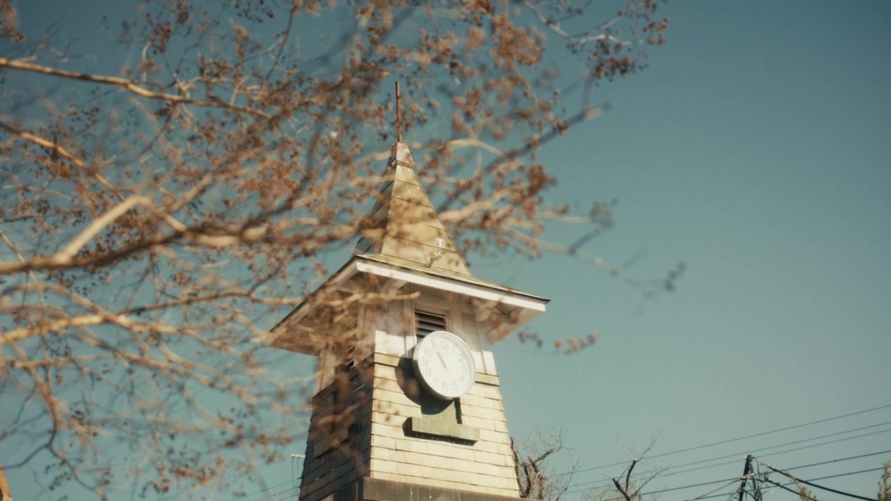 Inquadratura dal basso verso l'alto della torre dell'orologio ornamentale alla stazione di Kamakura, Kanagawa, Giappone, in una limpida mattina d'inverno