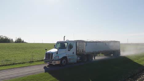 Semi-Truck-Driving-Along-Countryside-Road-in-Rural-Area-During-Daytime,-Aerial