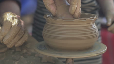 hands of old potter and young pupil