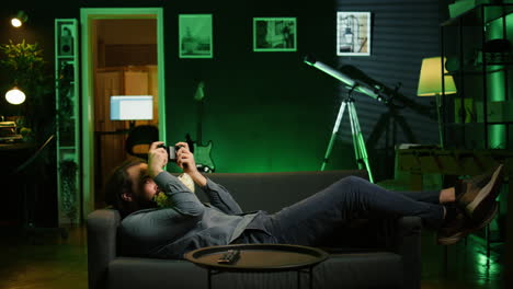 person in home theatre holding controller munching on popcorn