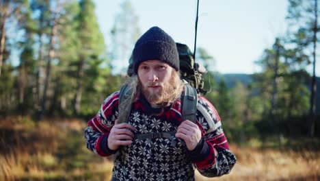 bearded norwegian guy with backpack in forest mountain during summer