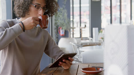 hombre tomando café mientras usa la tableta 4k