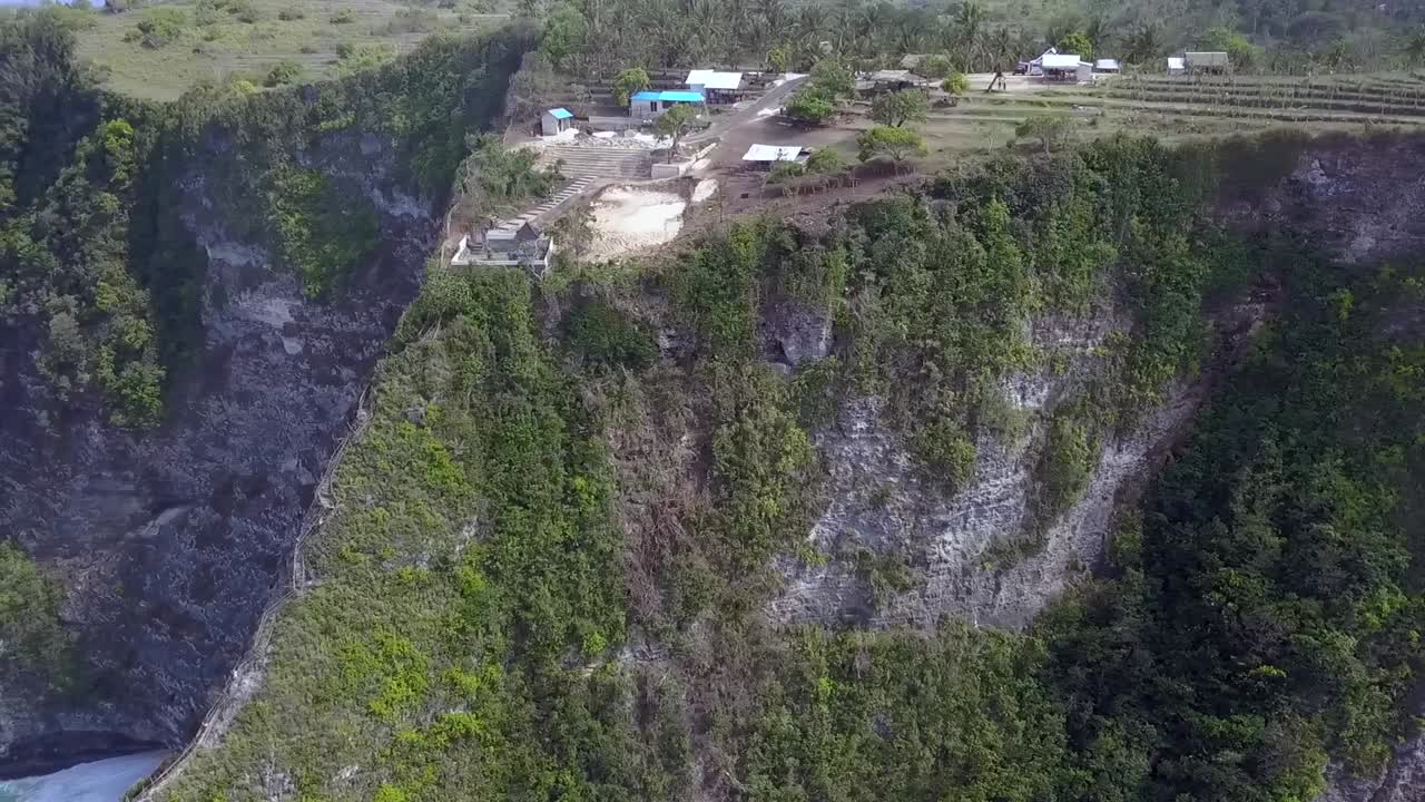 gran vista aérea vuelo deslizador volar lateralmente de derecha a izquierda tiro de dron kelingking playa en nusa penida en bali indonesia es como parque jurásico