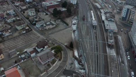 aerial of large trainyard near city in winter