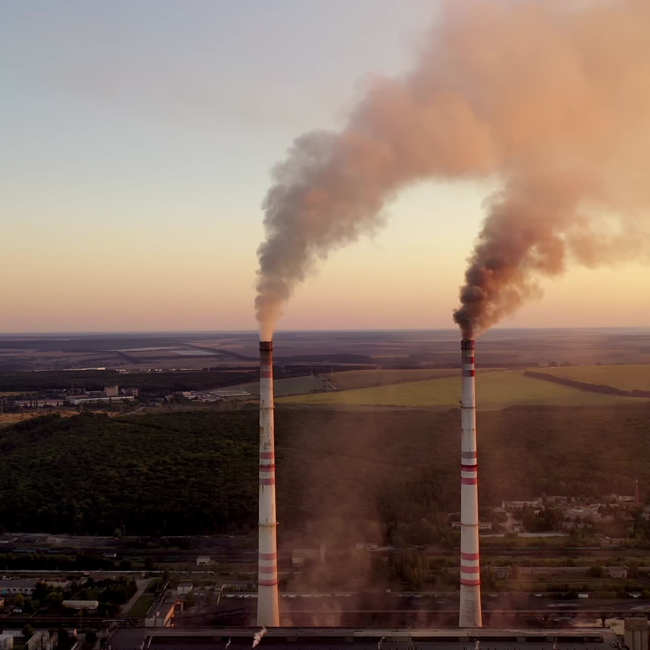 Industrial pipes with smoke in the evening. Toxic emissions from power plant filling the atmosphere. Environmental problems. Global warming.