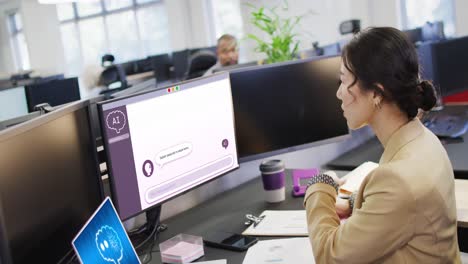 Asian-businesswoman-using-computer-with-digital-chat-on-screen-in-office