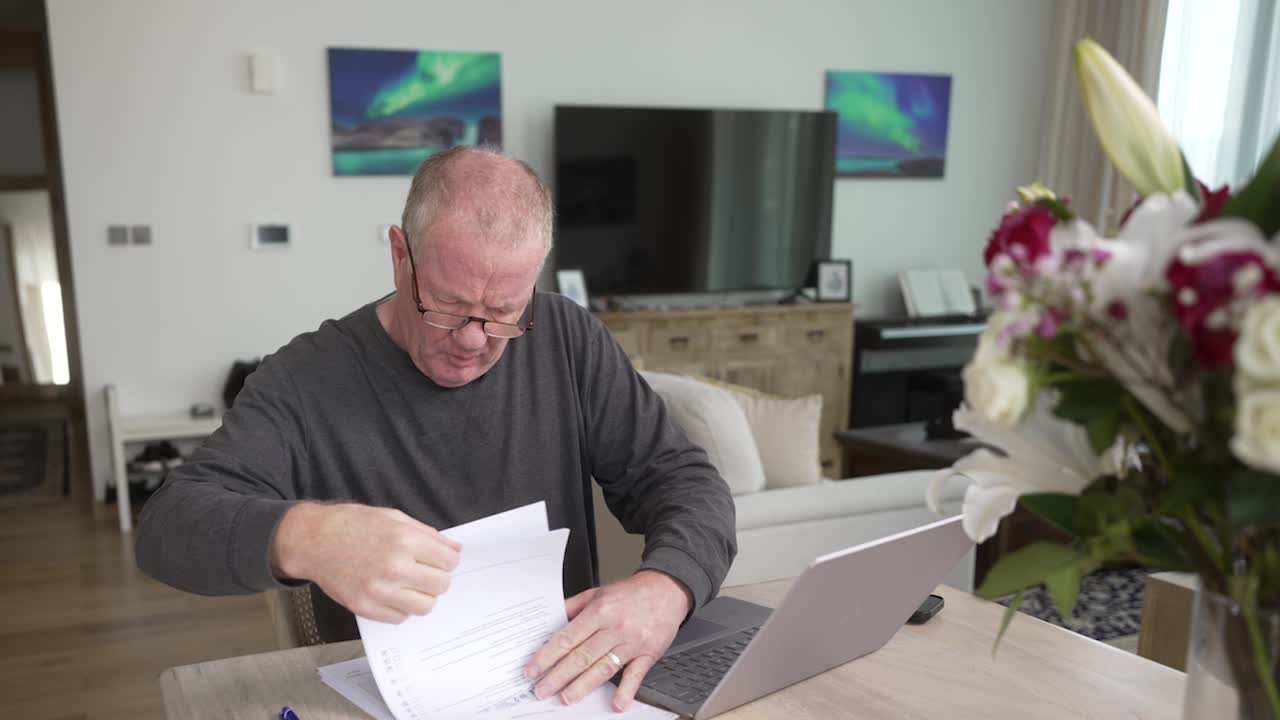 Older man frustrated with confusing tax forms and how to use computer software apps