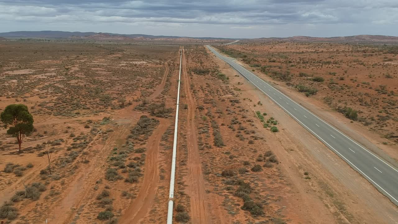 Drone flying above road and pipeline in outback Australia