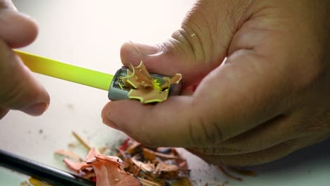 Imágenes-De-Manos-Afilando-Lentamente-Un-Lápiz-Y-Algunos-Lápices-De-Colores-Con-Un-Sacapuntas-De-Cuña