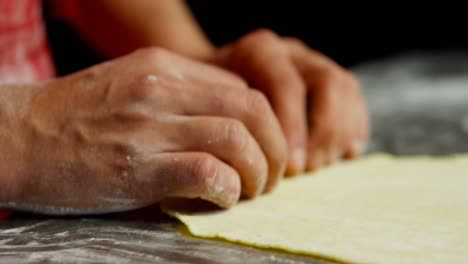 male baker rolling dough in bakery shop 4k