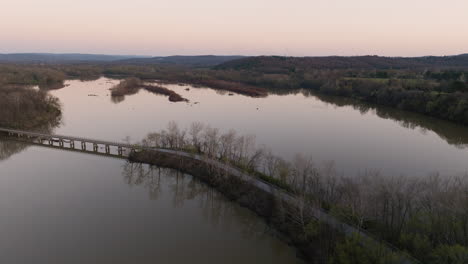 Toma-Aérea-De-Un-Puente-Que-Conecta-Ambas-Orillas-En-El-Lago-Sequoyah-Al-Atardecer