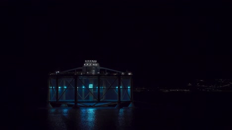 transporting modern salmon farm across fjord at night in trondheim, norway