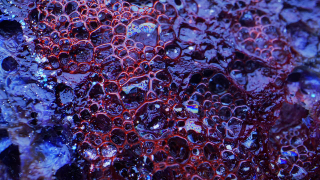 Macro view of a wet, bubbling surface with vibrant colors