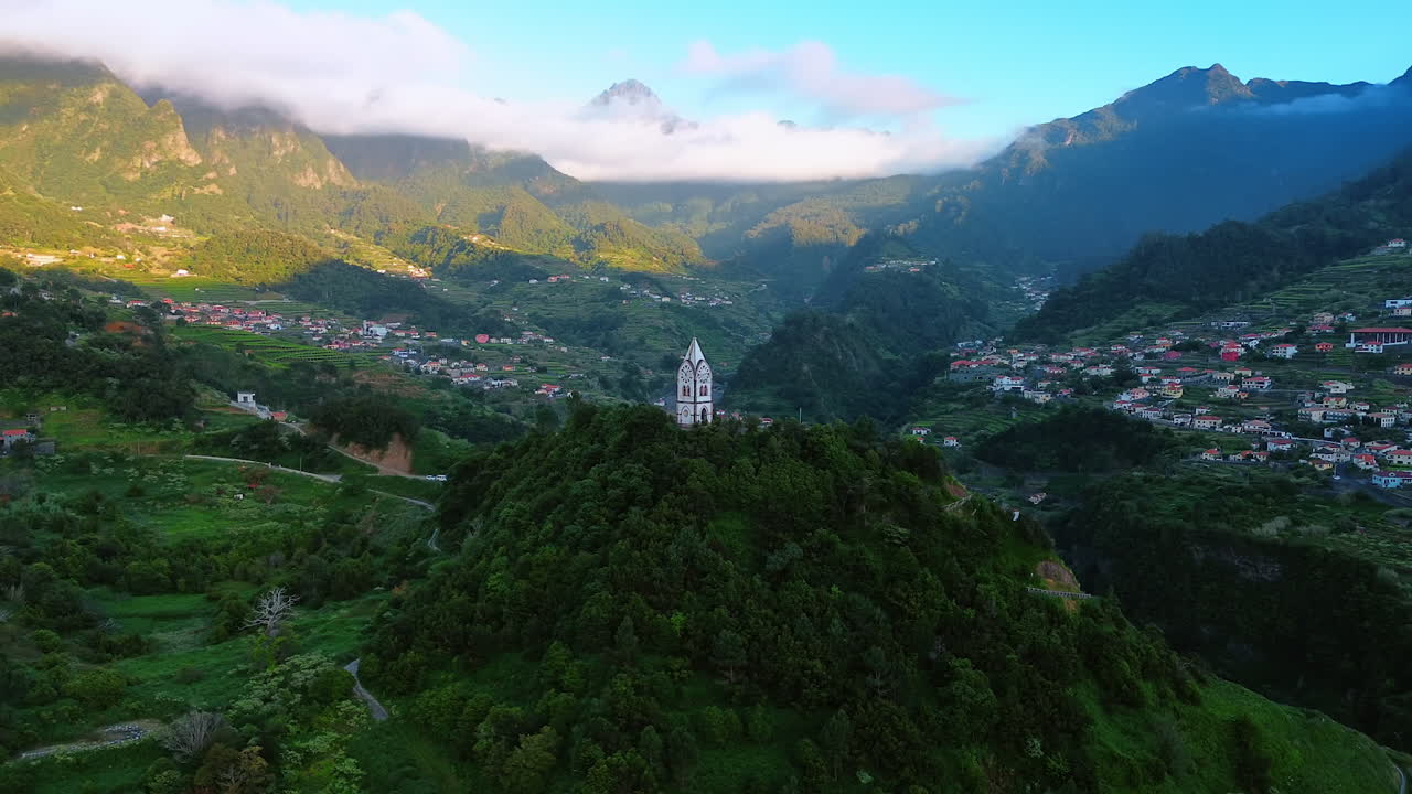 View on the Chapel of Our Lady of Fatima Sao Vicente, the Madeira Islands, Portugal. Aerial perspective on the stunning inhabited area located in the picturesque mountains. White cloudscape covers the tops of rocks.
