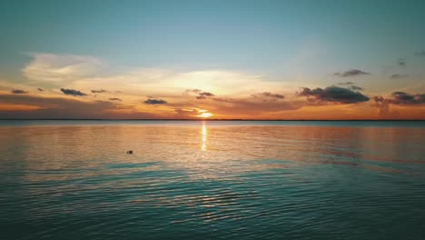 smooth forwards slowly rising up drone shot from a dream beach to the perfect paradise sunset