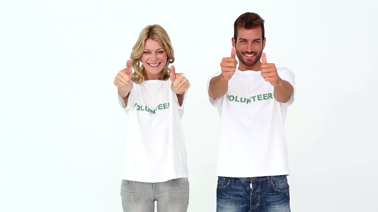 Two volunteers giving thumbs up to camera