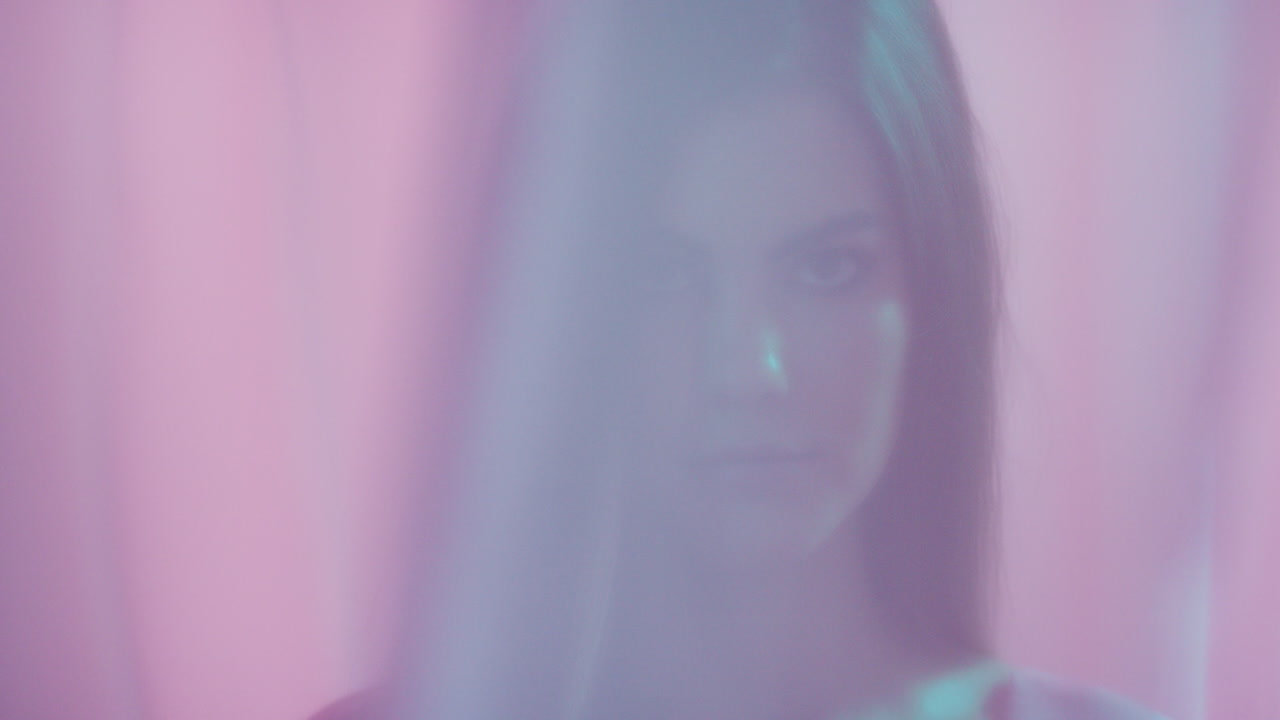 multicolored fantasy beautiful young woman looking seductive between sheets sensual feminine beauty curtains blowing in colorful background