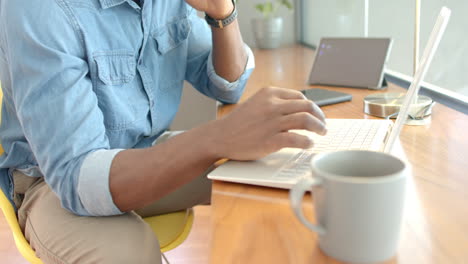 working from home, man using laptop and drinking coffee in living room