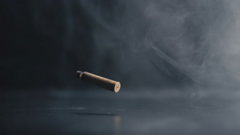 bullet casing descending with swirling smoke in background