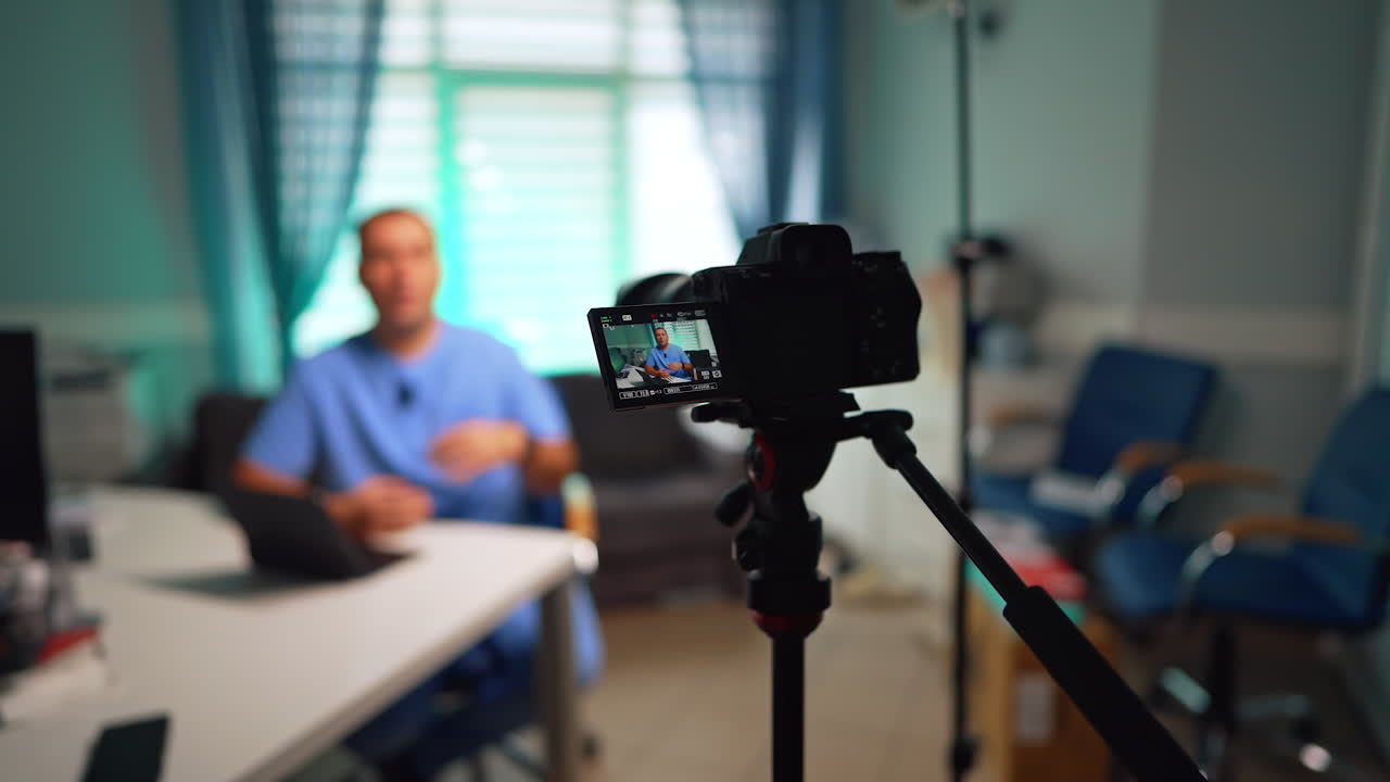 Modern camera set in the office records a man talking at the desk. Male doctor speaks for video content. Selective focus