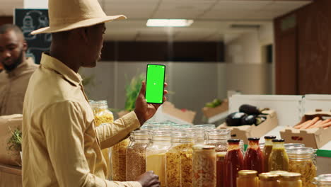 business owner presenting blank greenscreen display on phone