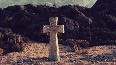 cruz de piedra en un paisaje desértico