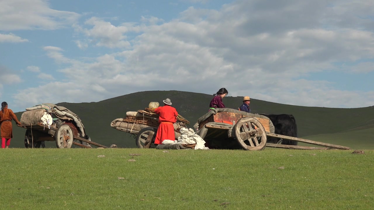 Keluarga Nomaden Mongolia Mengepak Gerobak Kayu Tradisional di Padang Rumput