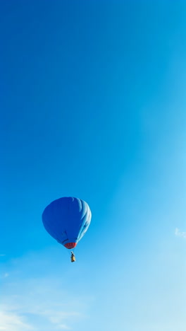 a blue hot air balloon soaring in a clear blue sky