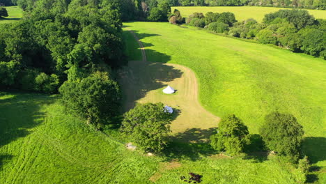 Aerial-titling-down-to-Great-Oaks-Glamping-Sunny-day-UK-4K