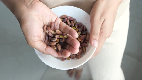 mujer sosteniendo un plato de pistachos