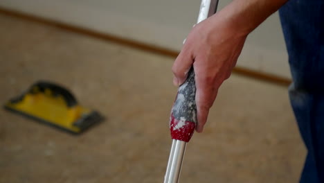 person rolls paint onto paint roller in slow motion