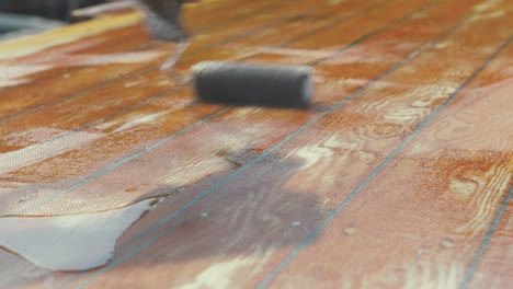 rolling epoxy over woven fiberglass mat on a planked roof