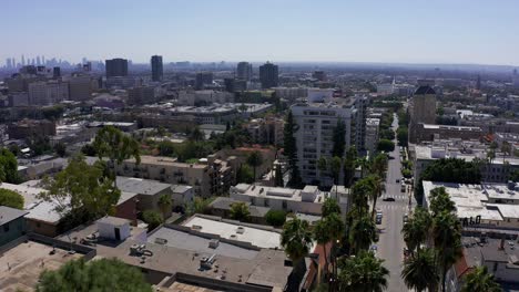 Toma-Aérea-Panorámica-Baja-En-El-Centro-De-Hollywood-Con-El-Centro-De-Los-ángeles-En-La-Distancia