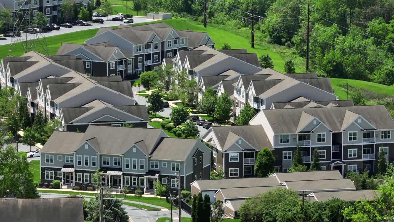 Classical american apartment block and townhouses in well-kept suburb housing area. Sunny day and green trees in May. Aerial wide shot. Pennsylvania, United states.