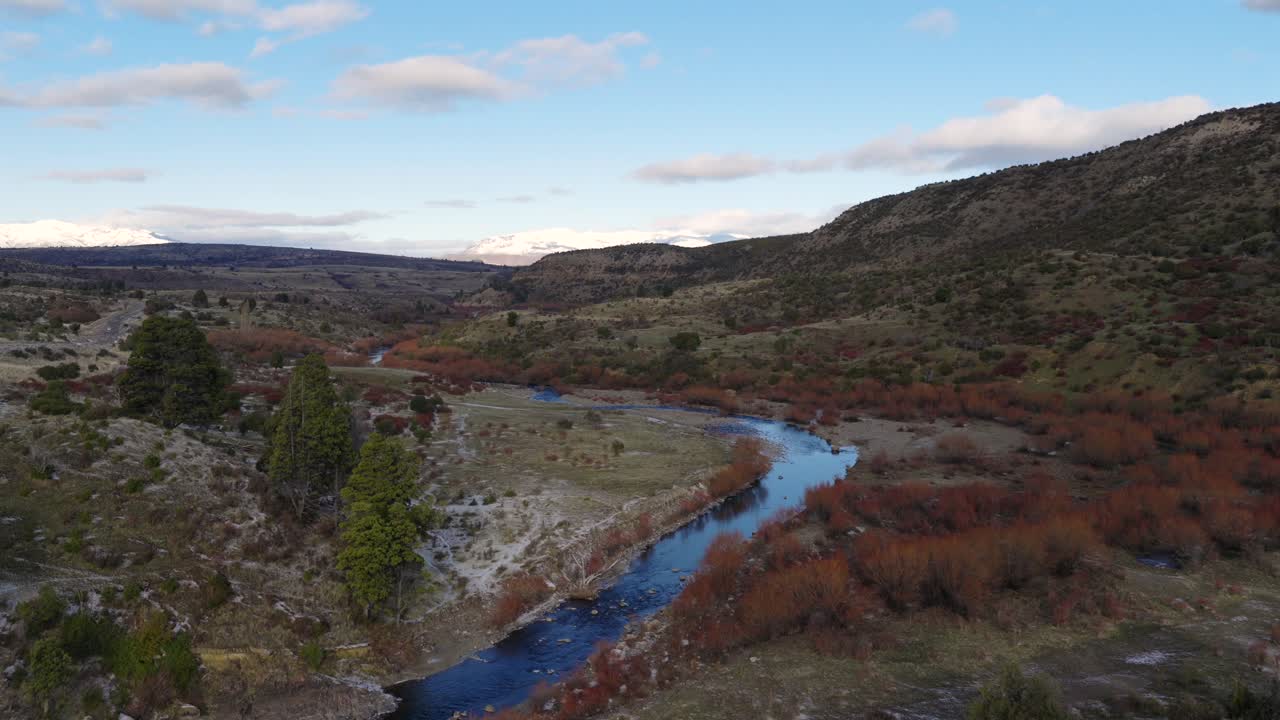 Panorama drone view of Patagonian landscape of river curving through mountain valley, Argentina