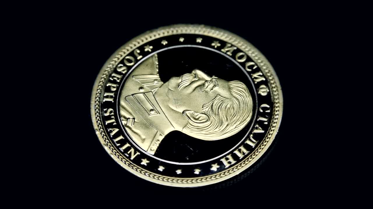 Russian souvenir coin Joseph Stalin rotates on a black background. Macro. Closeup